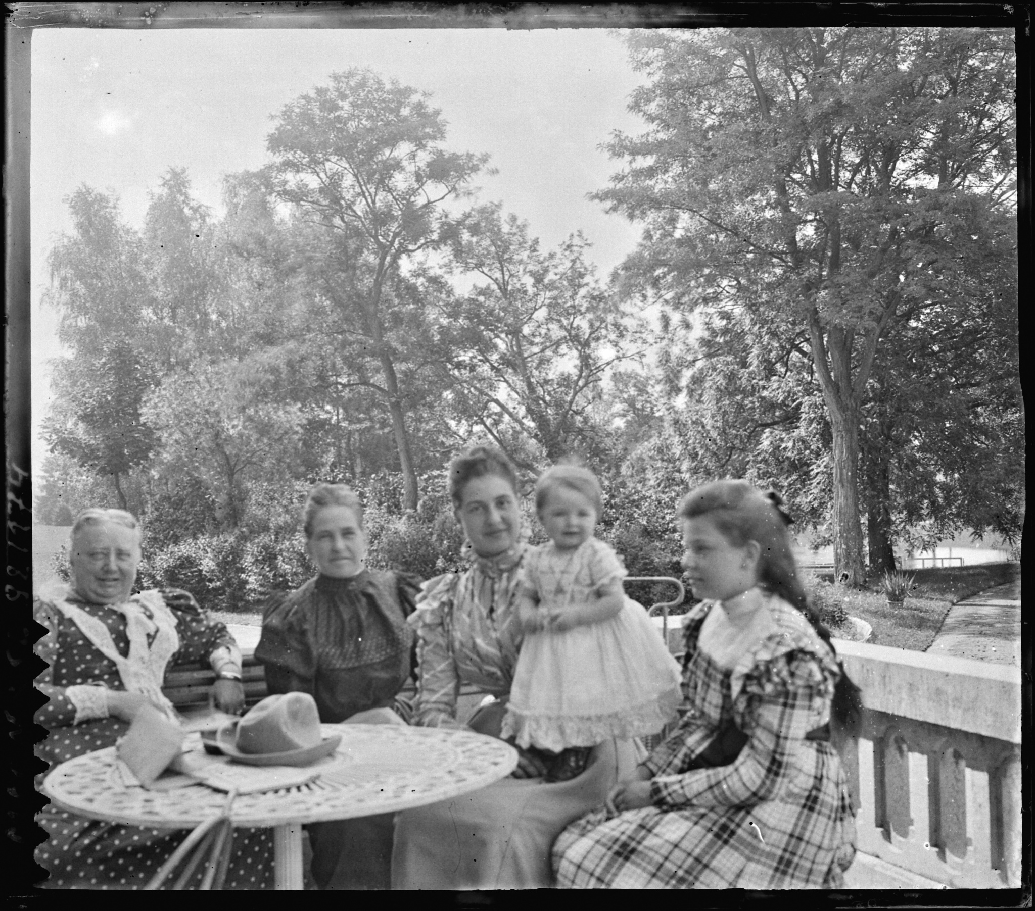 Groupe de femmes de Sélys avec un bébé alentour d'une table en terrasse.
