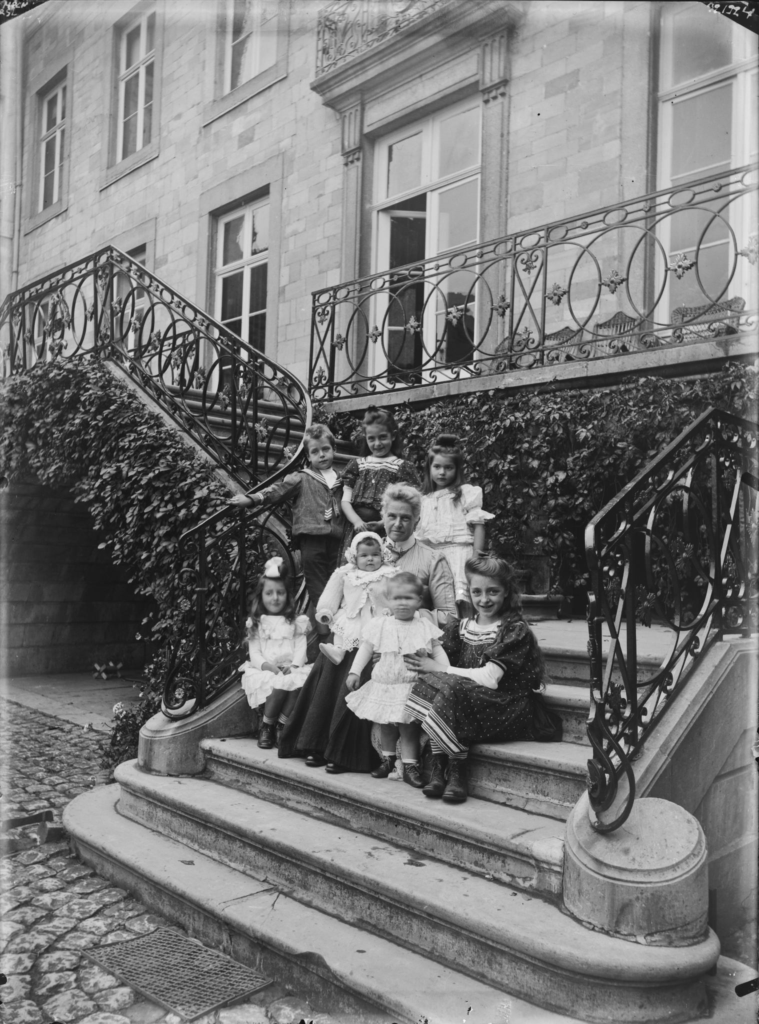 Eusébie de Brigode entourée d'enfants sur les marches d'escalier du château de Borgharen