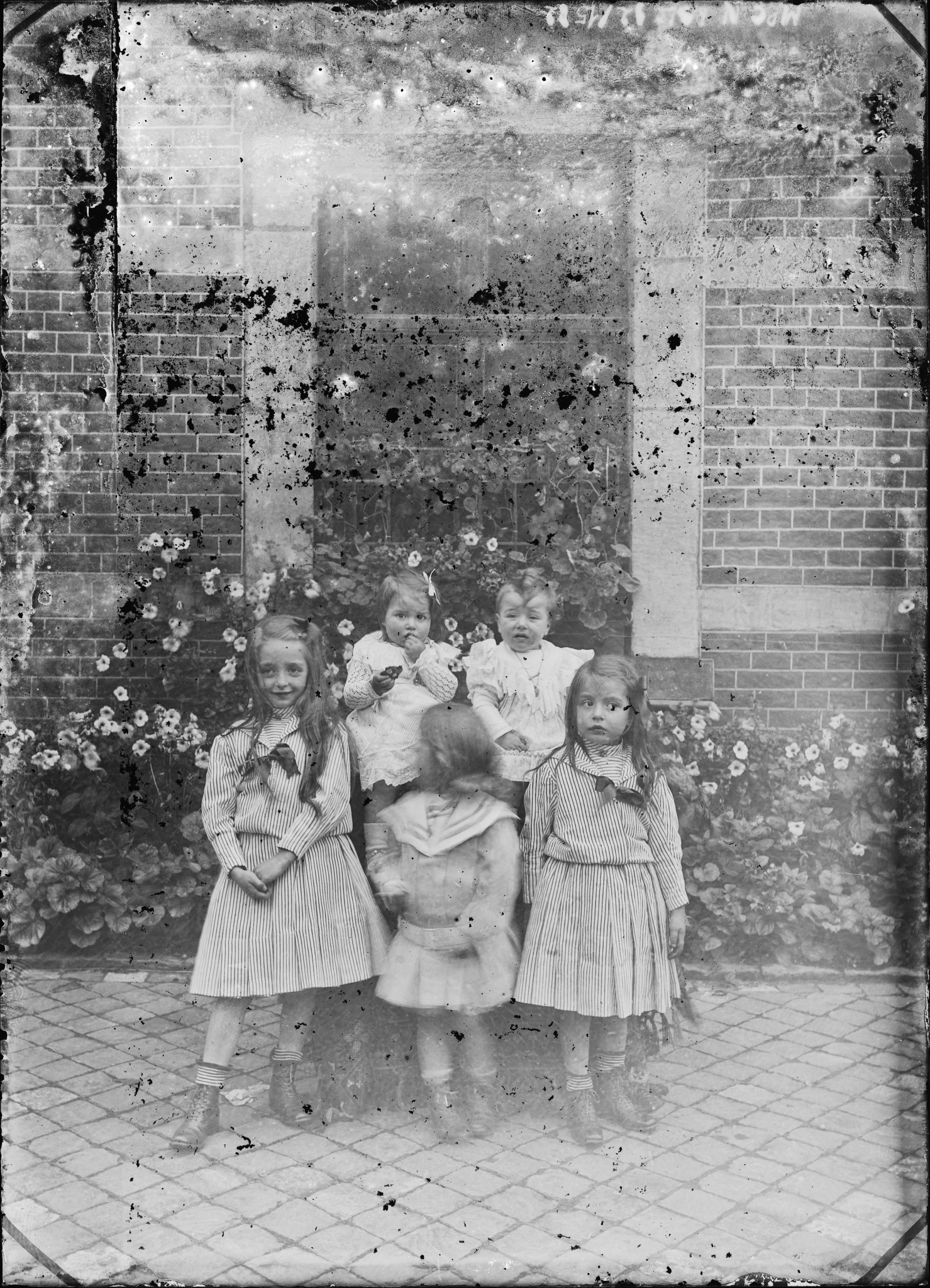 Portrait de cinq enfants contre une façade fleurie