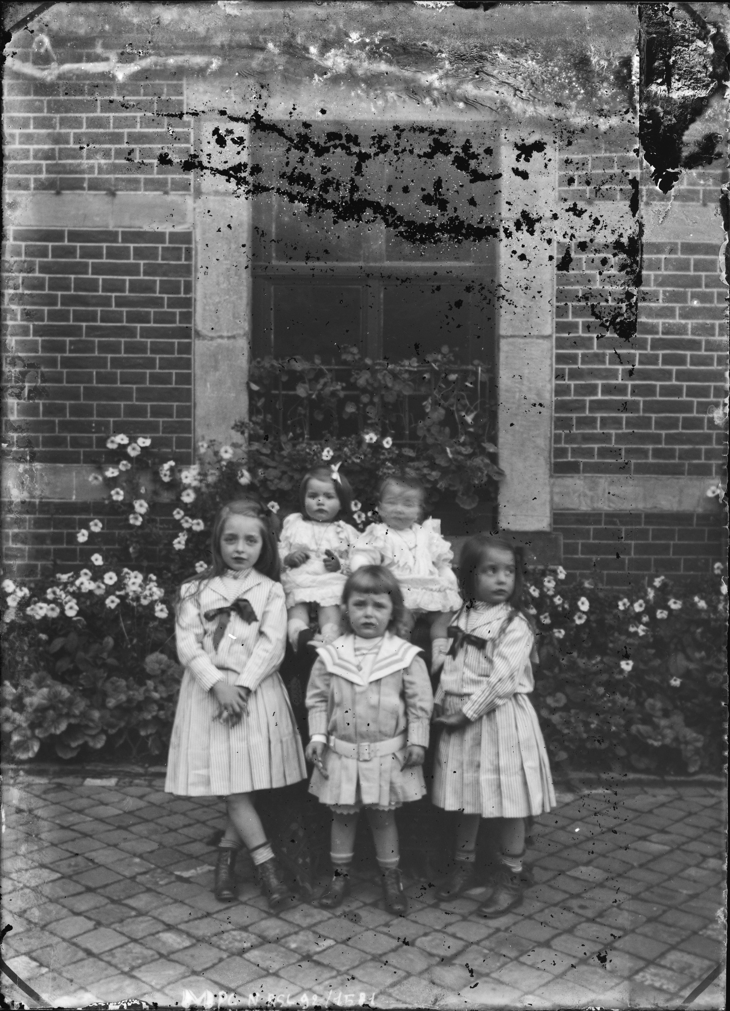 Portrait de cinq enfants contre une façade fleurie
