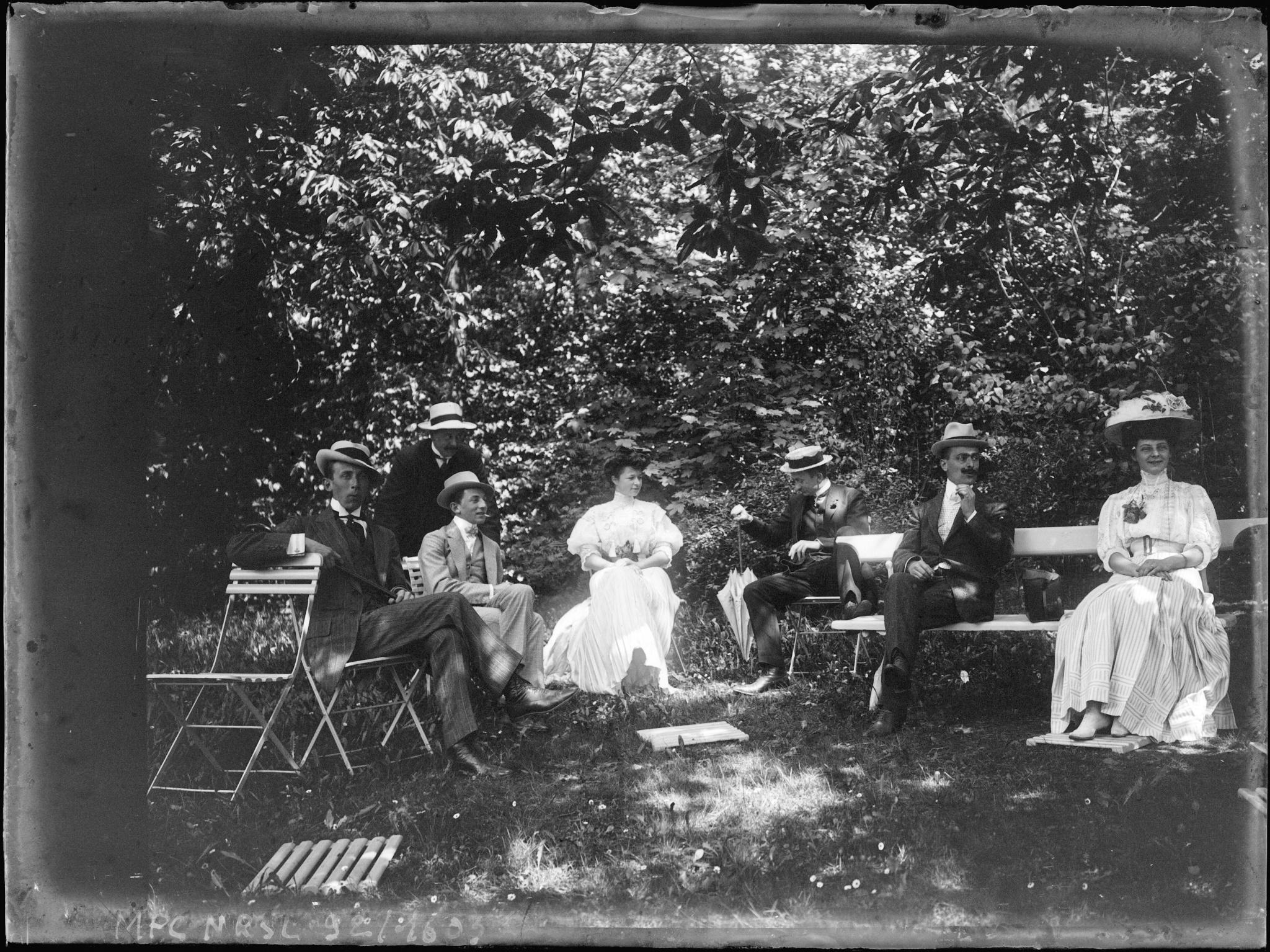 Groupe assis sur des bancs et chaises dans un jardin