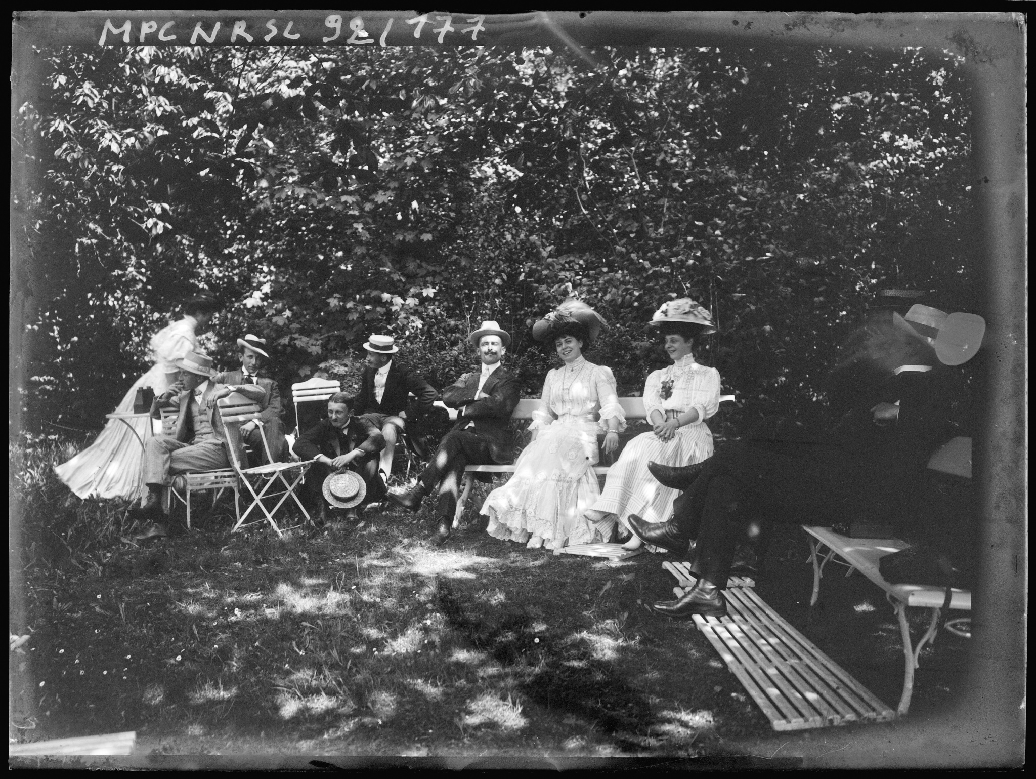 Groupe assis sur des bancs et chaises dans un jardin
